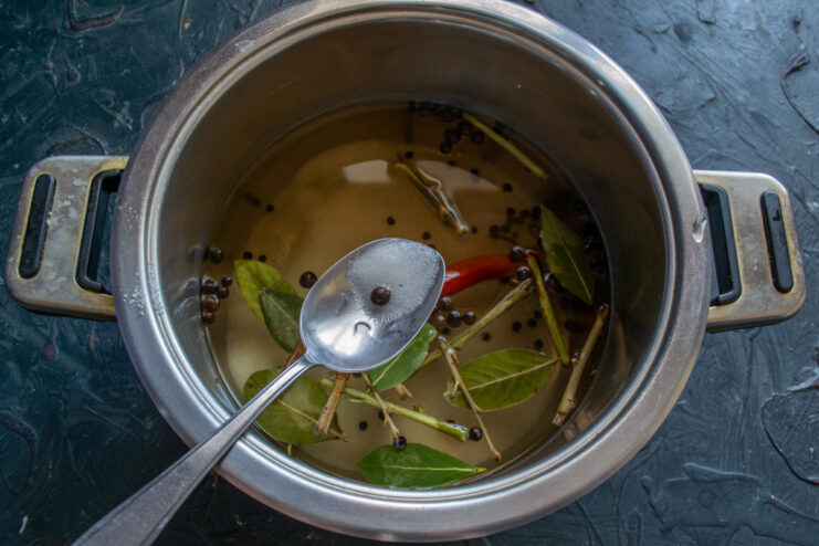 Step 4: Adding Salt and Sugar to the Cooled Brine Adding salt and sugar to the cooled aromatic brine in a pot.
