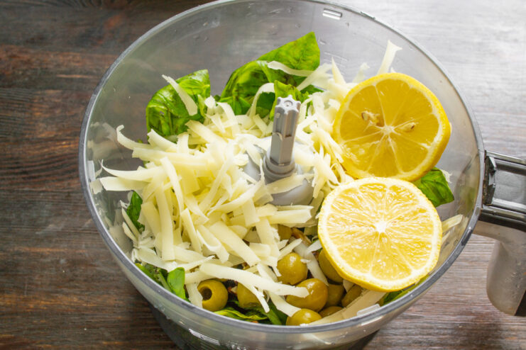 Squeezing fresh lemon juice for a bright pesto flavor Squeezing juice from half a lemon into the blender for the pesto sauce.