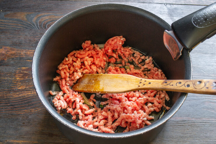 Sautéing onions and garlic to build the soup's flavor foundation. Sliced onions and minced garlic being added to a pot with oil.