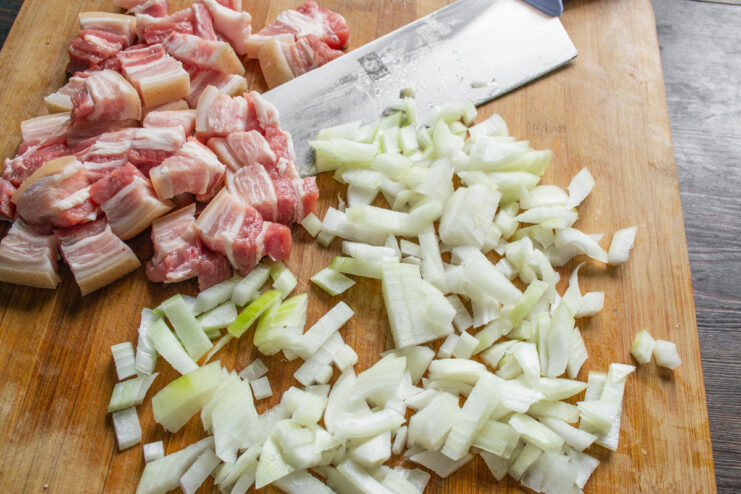 Dicing an Onion for the Pork Belly and Rice Recipe A large yellow onion being diced into small cubes on a cutting board.