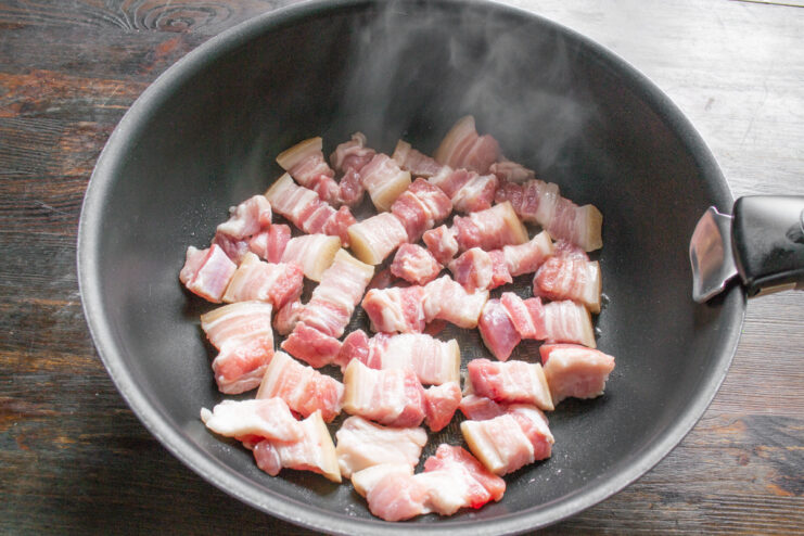 Choosing the Right Cookware: A Deep Skillet or Wok is Ideal A deep wok-style skillet with oil being heated on a stove, ready for cooking.