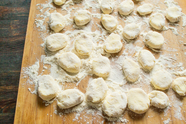 Forming the individual syrniki pancakes Flattening a small piece of syrniki dough into a circular pancake shape.