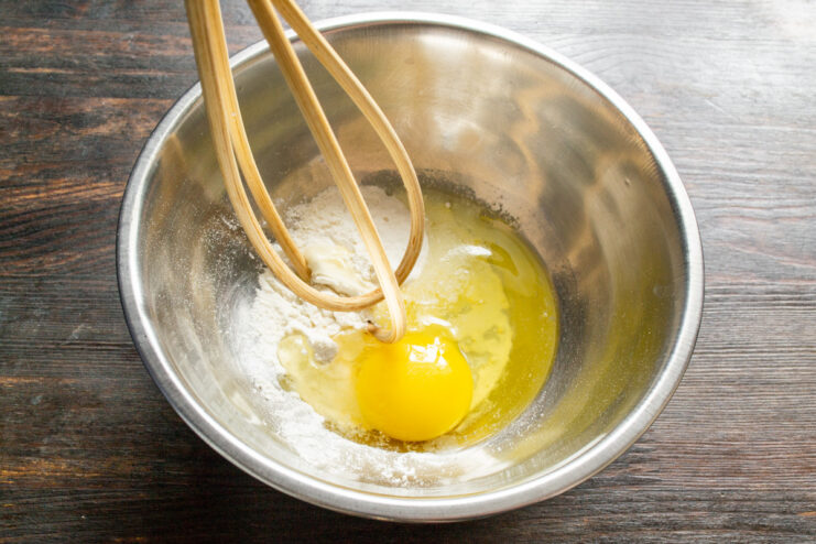 Making the custard: Whisking egg and flour together Whisking an egg and flour in a glass bowl to start the custard.