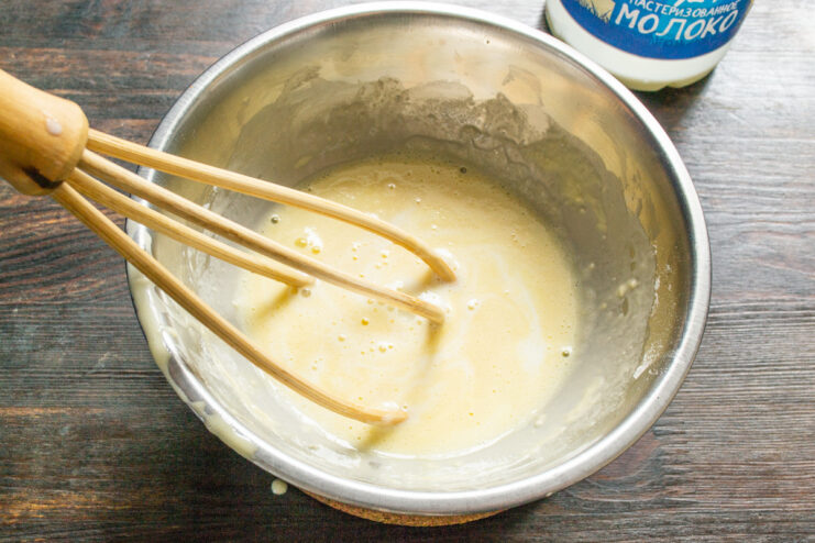 Adding cold milk to the custard base Pouring cold milk into the egg and flour mixture for the custard.