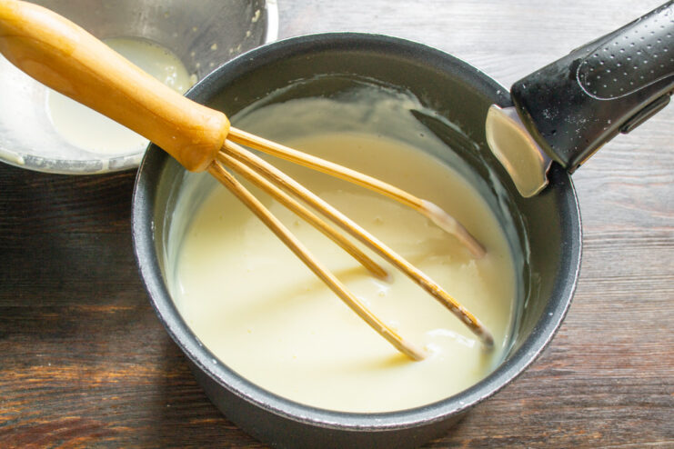 Tempering the eggs for the custard Pouring the egg mixture into hot milk in a saucepan to make custard.