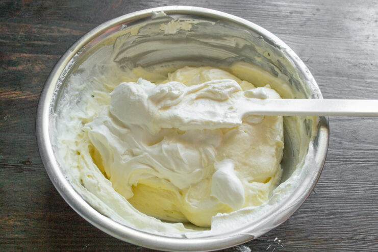 A bowl of Tiramisu cream being mixed, showing the process of folding in whipped cream.