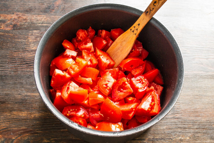 Step 1: Preparing the Fresh Tomatoes for the Sauce A metal saucepan filled with freshly chopped ripe red tomatoes.