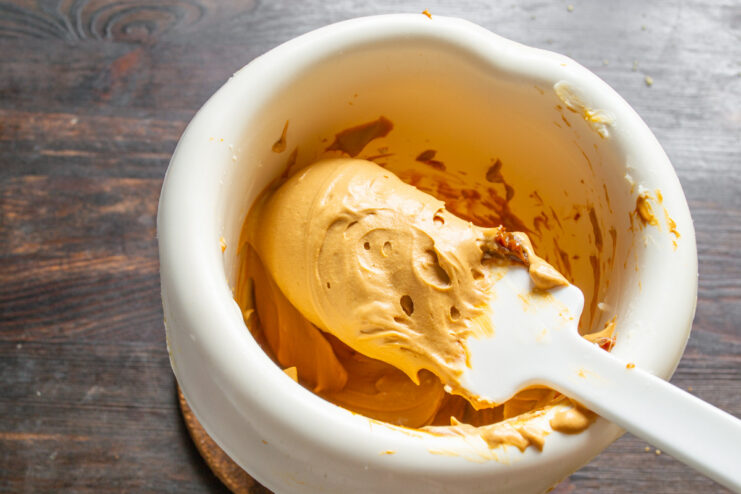 Step 5: Making the Caramel Cream Filling Varenaya sgushenka and mascarpone in a bowl, being mixed to create a creamy filling.