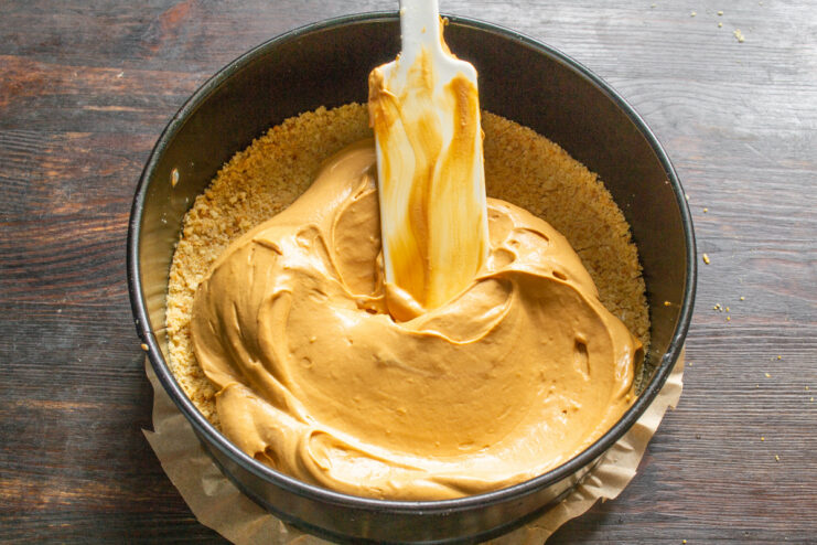 Step 6: Adding the Filling to the Crust Spreading the caramel cream filling evenly over the chilled cookie crust in a springform pan.