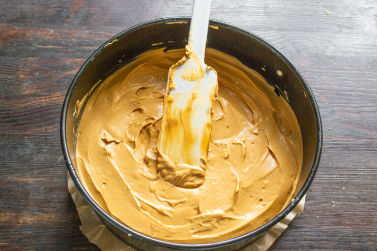 Step 7: Smoothing the Cream Filling A spatula smoothing the surface of the caramel cream filling on the no-bake cake.