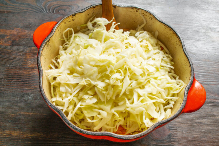 How to Perfectly Shred Cabbage for Braising A pile of finely shredded white cabbage, ready for cooking.