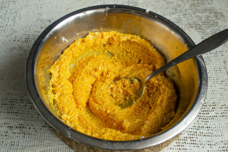 Adding Sugar to the Tvorog and Pumpkin Mixture Granulated sugar being poured into a bowl with the tvorog and pumpkin mixture.