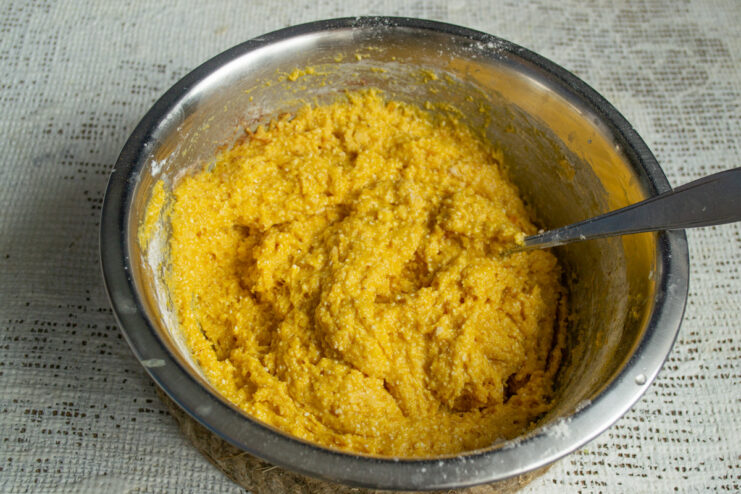 Mixing the Thick Tvorog and Pumpkin Cake Batter A thick, orange-colored batter for the tvorog and pumpkin loaf cake in a mixing bowl.