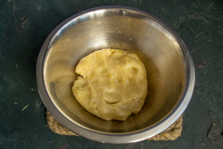 Step-by-step: Combining dry ingredients with lemon zest to make the pie dough. A bowl with flour, baking powder, and grated lemon zest, ready for mixing the pie dough.
