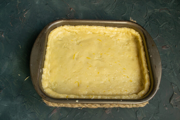 Creating a neat crust: Trimming the excess dough from the baking dish. Trimming the excess dough from the edges of a rectangular baking dish to form a neat crust.