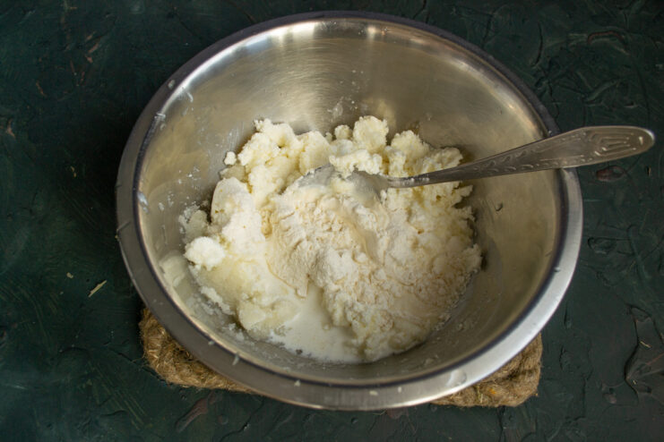 For a creamy texture: Pouring heavy cream into the cottage cheese filling. Pouring heavy cream into a bowl with the cottage cheese filling ingredients.