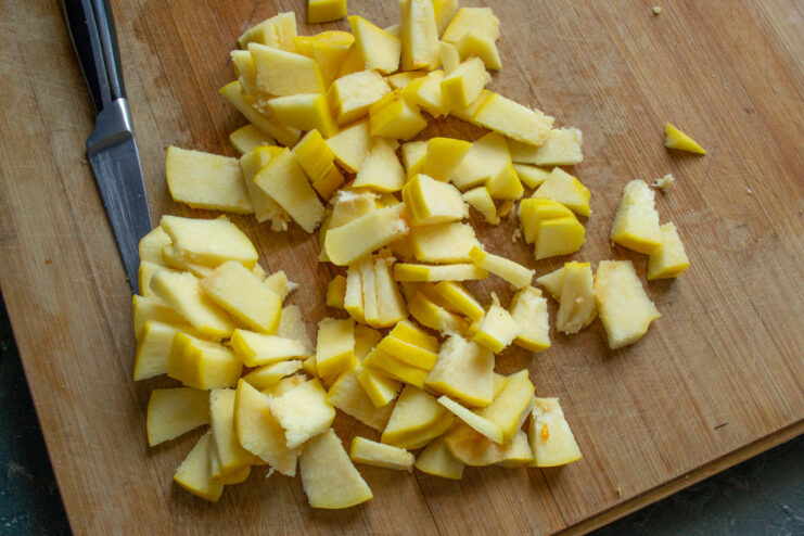 How to Finely Slice Quince for a Perfect Jam Texture A pile of thinly sliced quince pieces on a cutting board, ready for making jam.