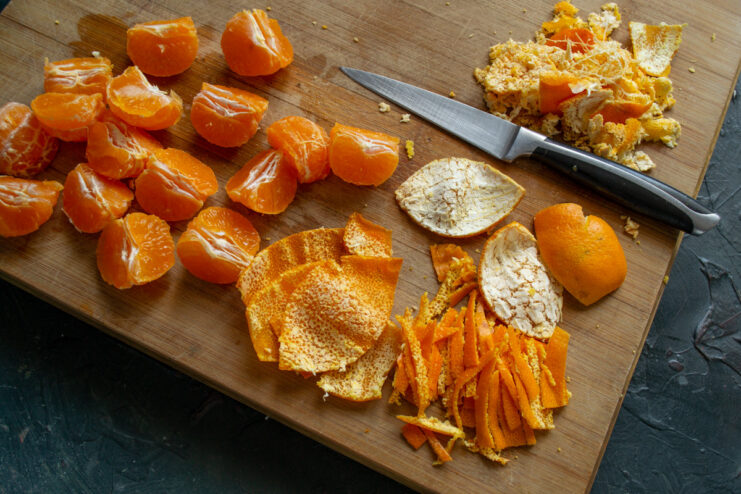 Preparing Mandarins: Separating the Peel for Aromatic Jam Mandarins being cut into quarters and the peel being separated from the fruit segments.