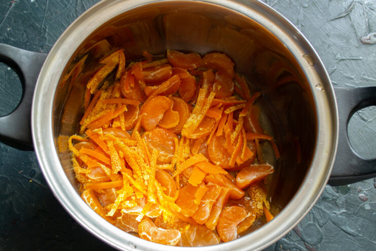 Starting the Jam: Combining Mandarin Peel and Segments in a Pot Mandarin peel and fruit segments in a heavy-bottomed pot, the first step of making jam.