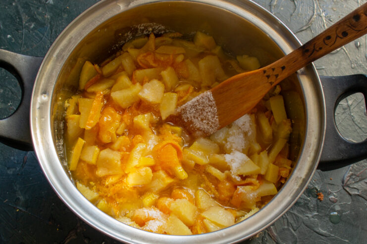 Creating the Syrup: Letting the Sugar Dissolve into the Fruit A close-up of the fruit and sugar mixture in the pot as the sugar dissolves into a syrup.