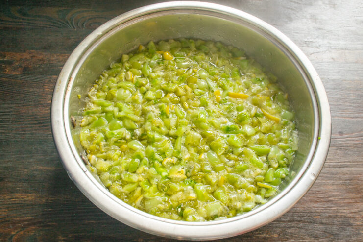 Simmering the Green Tomato Jam The green tomato jam simmering on low heat in a covered pan.