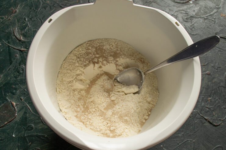 Sifting Flour for the Vatrushki Dough Sifting white flour into the metal bowl of a stand mixer.