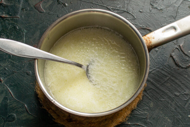 Warming Milk and Oil for the Yeast Dough A small saucepan with milk, sugar, salt, and oil being warmed on a stove.