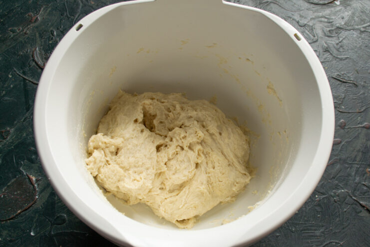 Initial Mixing of the Dough with a Dough Hook A stand mixer with a dough hook attachment starting to combine the ingredients for the dough.