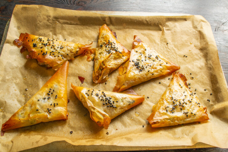 Baking the Samsa Until Golden Brown A baking sheet with samsa pastries inside a hot oven, baking until golden.