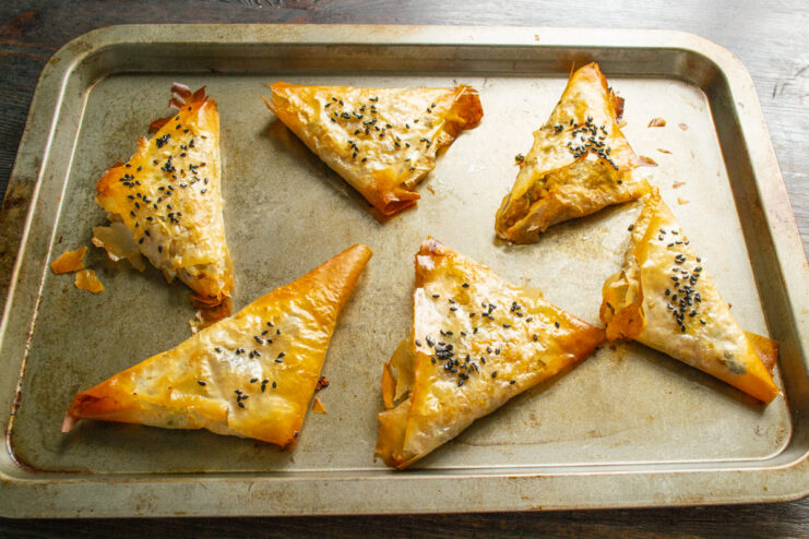Enjoying Freshly Baked Vegetarian Samsa A close-up of golden, crispy vegetarian samsa with bulgur, fresh out of the oven.
