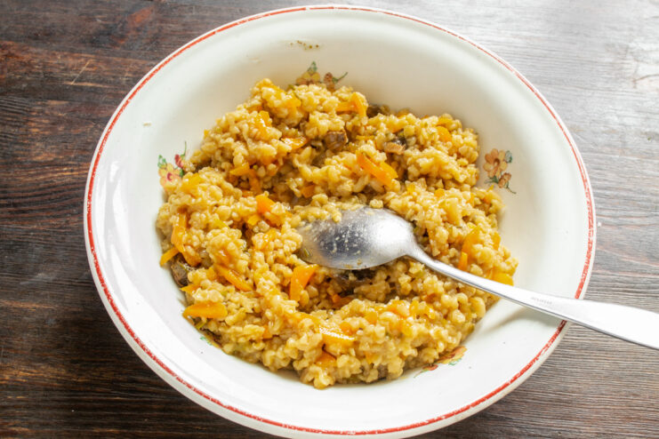 Preparing the Savory Bulgur Filling for Samsa A skillet with sautéed carrots and onions being mixed with cooked bulgur for the samsa filling.