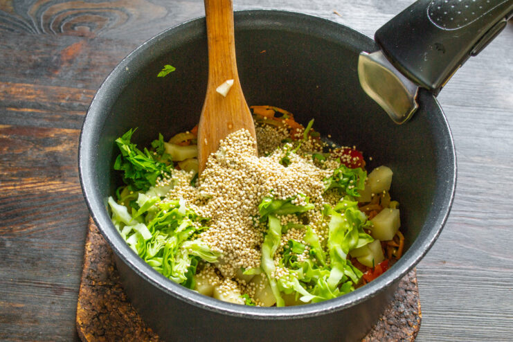 Adding protein-rich quinoa to the vegetarian soup Quinoa being poured from a measuring cup into the soup pot.
