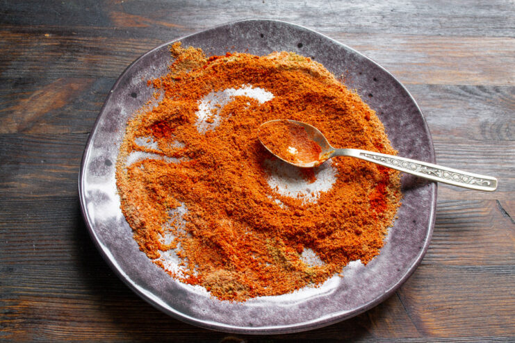 Preparing the Final Spice Coating for the Ham A small bowl containing a mixture of ground spices like paprika for the ham coating.