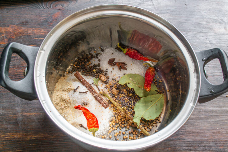 Creating the Aromatic Marinade for the Beef Ham A pot filled with water and various spices like bay leaves, peppercorns, and star anise for the marinade.