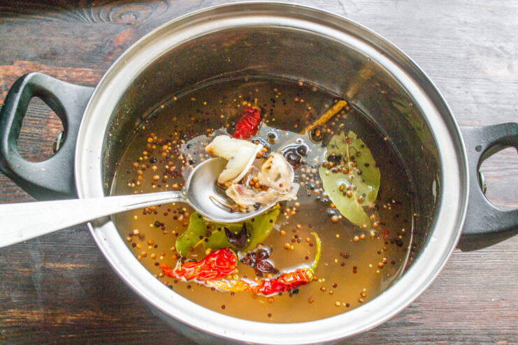 Bringing the Marinade to a Boil to Infuse Flavors A pot of marinade with spices boiling on a stove.