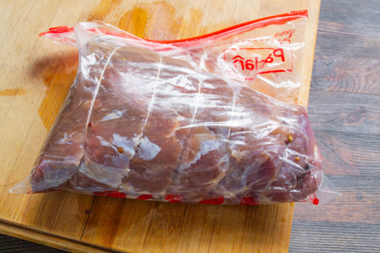 Preparing the Water Bath for Cooking the Beef Ham A sealed bag containing the beef is submerged in a large pot of hot water.