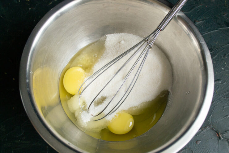 Step 1: Mixing eggs and sugar for the cake batter A glass bowl containing eggs and granulated sugar, ready for mixing.