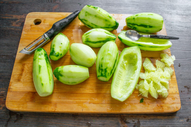 Removing the Large Seeds from the Cucumbers A cucumber cut in half, with a spoon scooping out the large seeds from the center.