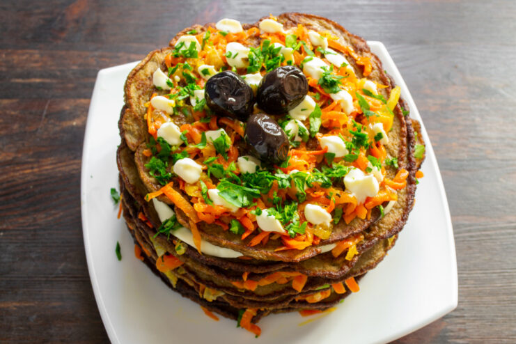 Final touches: garnishing the savory liver cake before serving The finished beef liver cake decorated with a mayonnaise lattice, fresh parsley, and black olives.