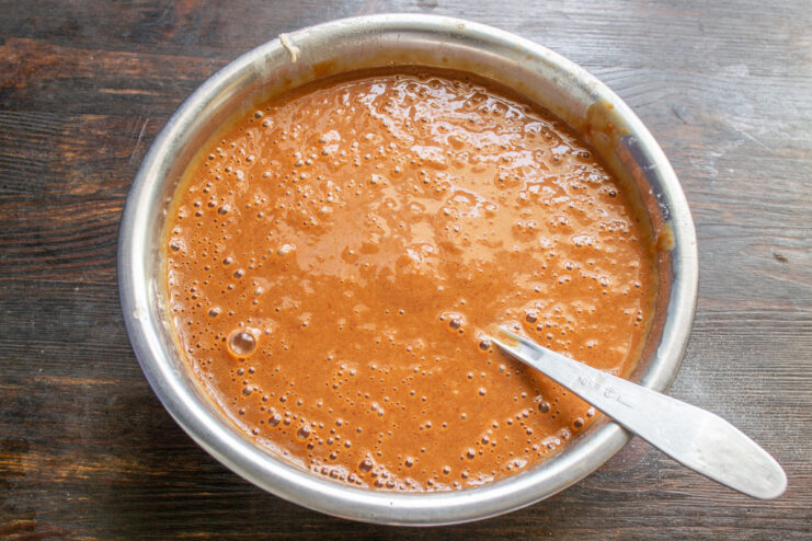 Blending the liver batter until it reaches a smooth, creamy consistency A hand blender processing the liver, onion, egg, milk, and flour into a smooth batter.