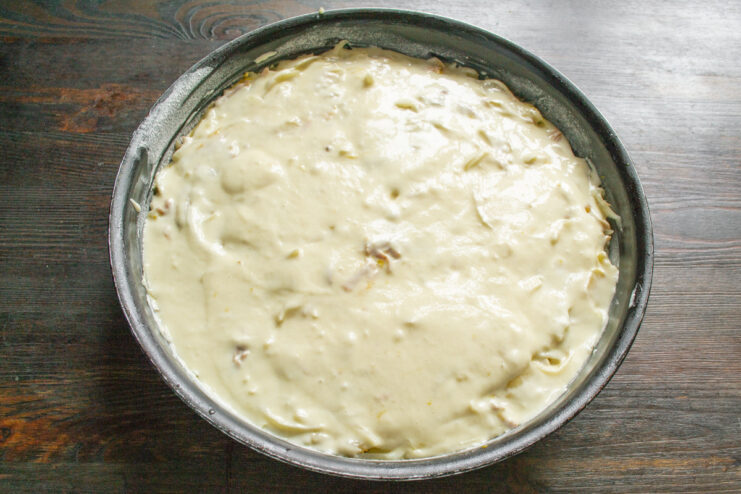 Covering the filling completely with the remaining batter to encase it. Pouring the rest of the batter over the filling in the baking pan.