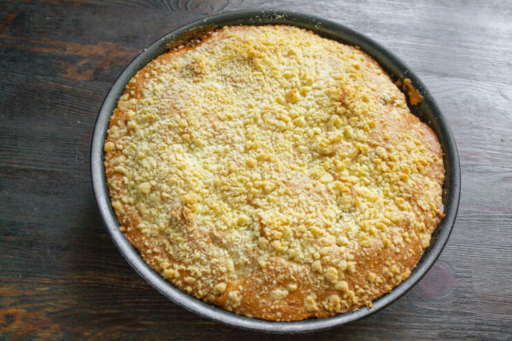 Tip: Let the pie cool completely for the best texture The fully baked golden-brown apple batter pie cooling in its baking dish.