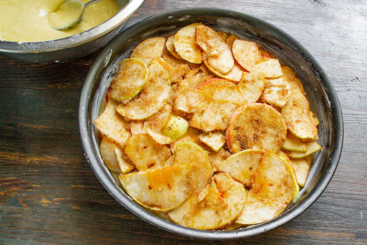 Step 8: Layering the apple filling over the batter Arranging sliced apples in overlapping layers over the batter in the baking dish.