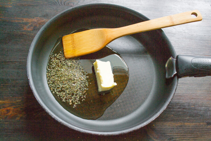 Olive oil and butter being added to a large skillet.