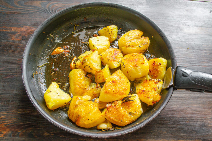 A skillet with smashed potatoes ready to be placed in the oven.