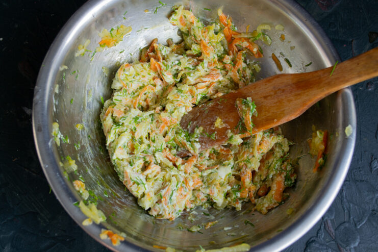 Mixing the Potato Topping A bowl with the cream cheese, vegetable, and herb filling being mixed together.
