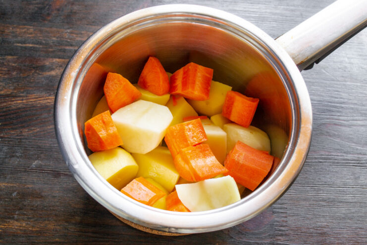 Parboiling Potatoes and Carrots for the Casserole Diced potatoes and carrots being boiled in a pot.