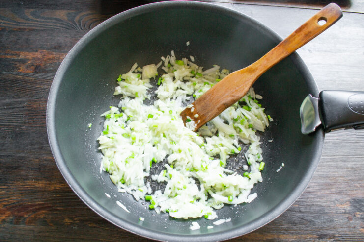 Sautéing Onions Until Soft and Fragrant Chopped onions being sautéed in a pan until translucent.