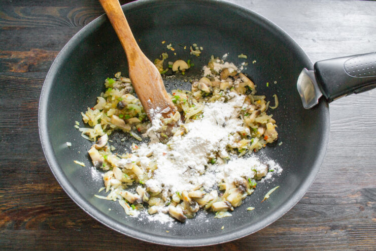 Cooking the Flour with Vegetables to Thicken the Sauce Mushrooms, onions, and flour being cooked together in a pan.