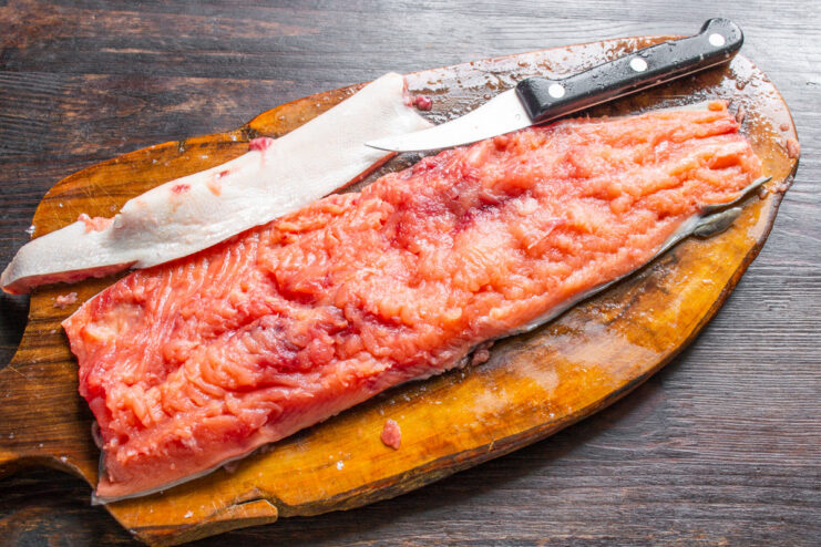 Filleting Pink Salmon for Curing Using a sharp knife to carefully separate a pink salmon fillet from its backbone.